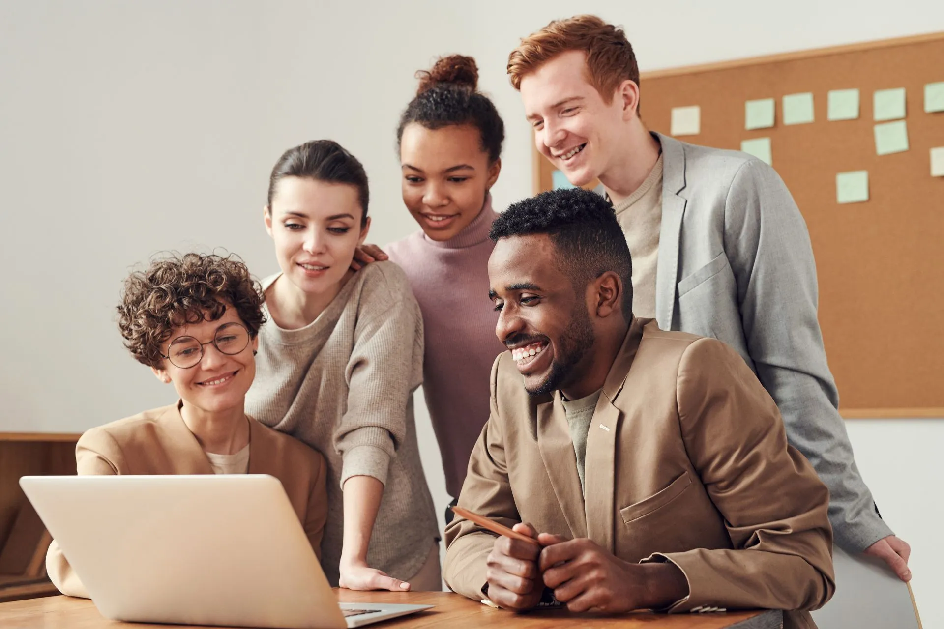 Een lachend team kijkt samen naar een laptop